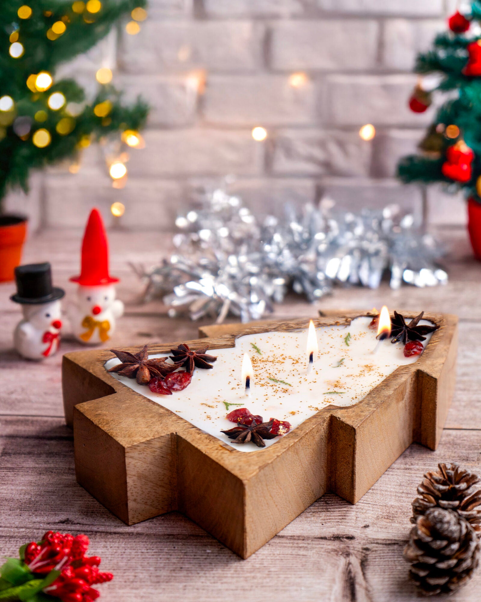 Eco-friendly soy wax candle shaped like a Christmas tree, featuring holiday decor and warm lighting.