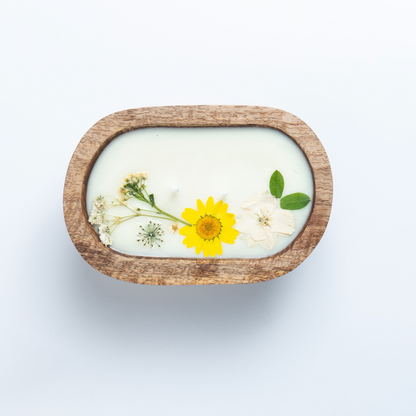 Bar of soap with a wooden casing and embedded yellow flower on a white background