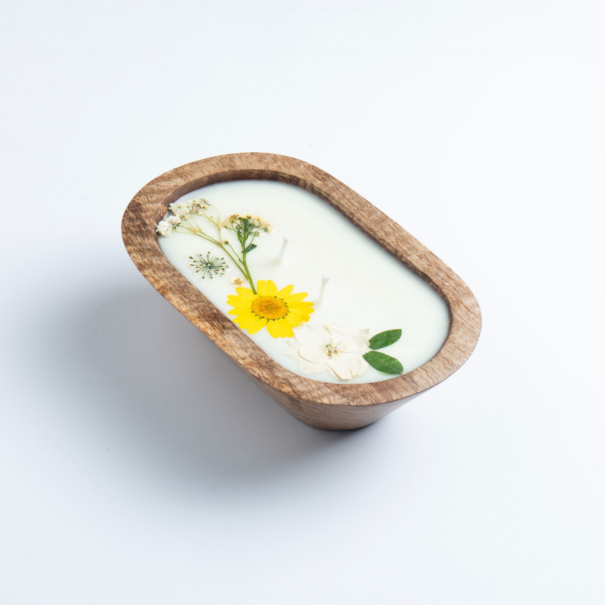 Candle in a wooden holder with flowers on a white background