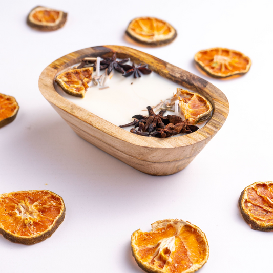 Wooden bowl with candles and dried oranges on a white background