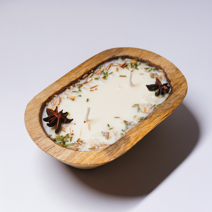 Candle in a wooden holder with star anise and cinnamon on a white background