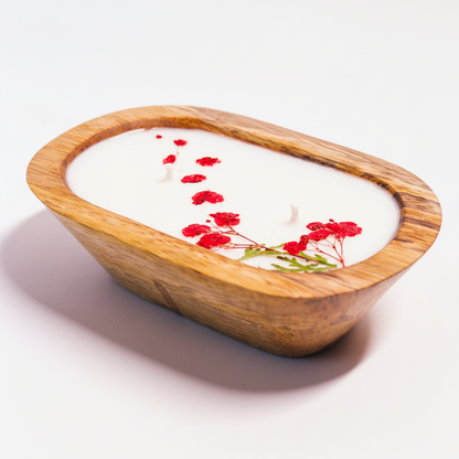 Wooden bowl with white candle and red flowers on a white background