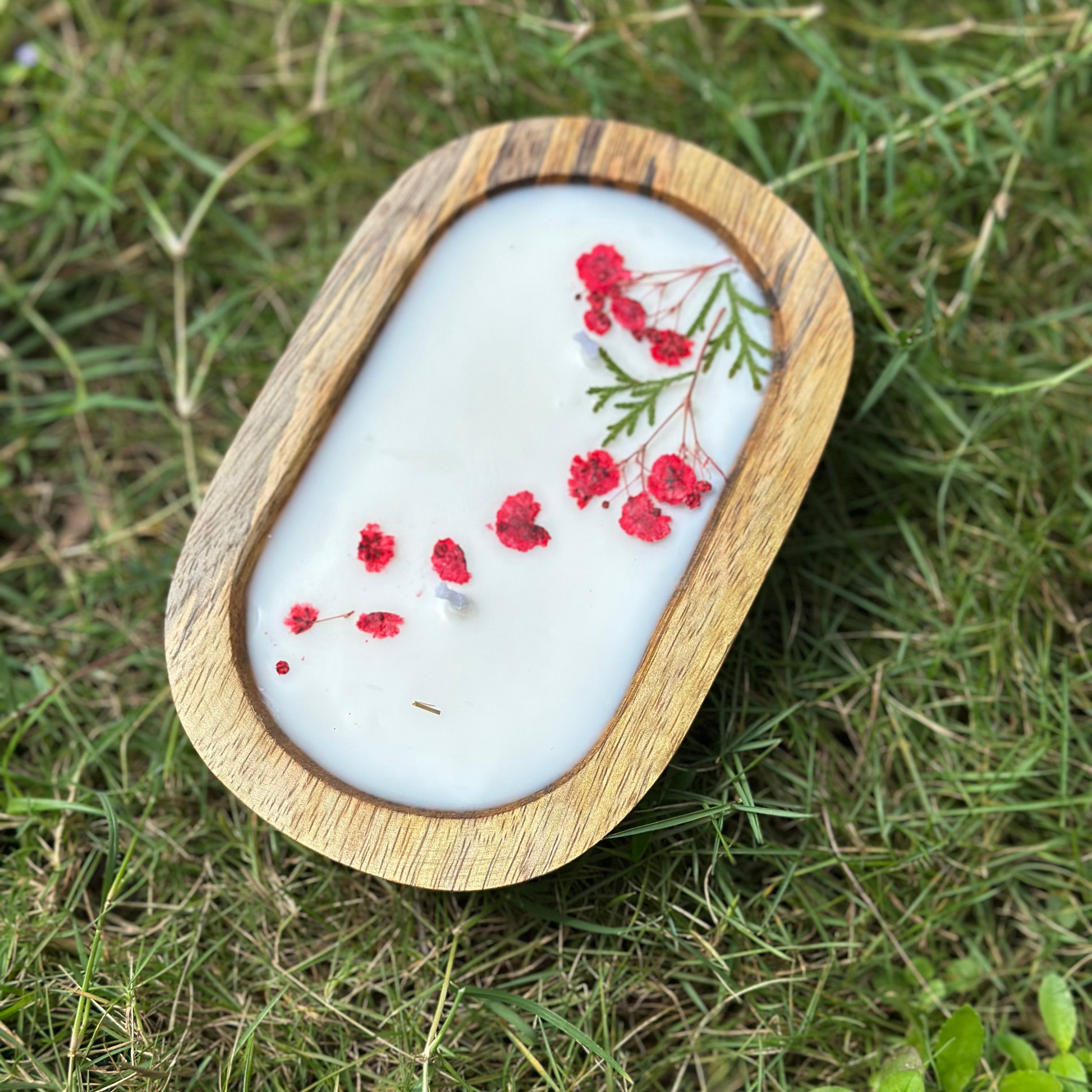 Decorative stone with floral design in a wooden frame on grass