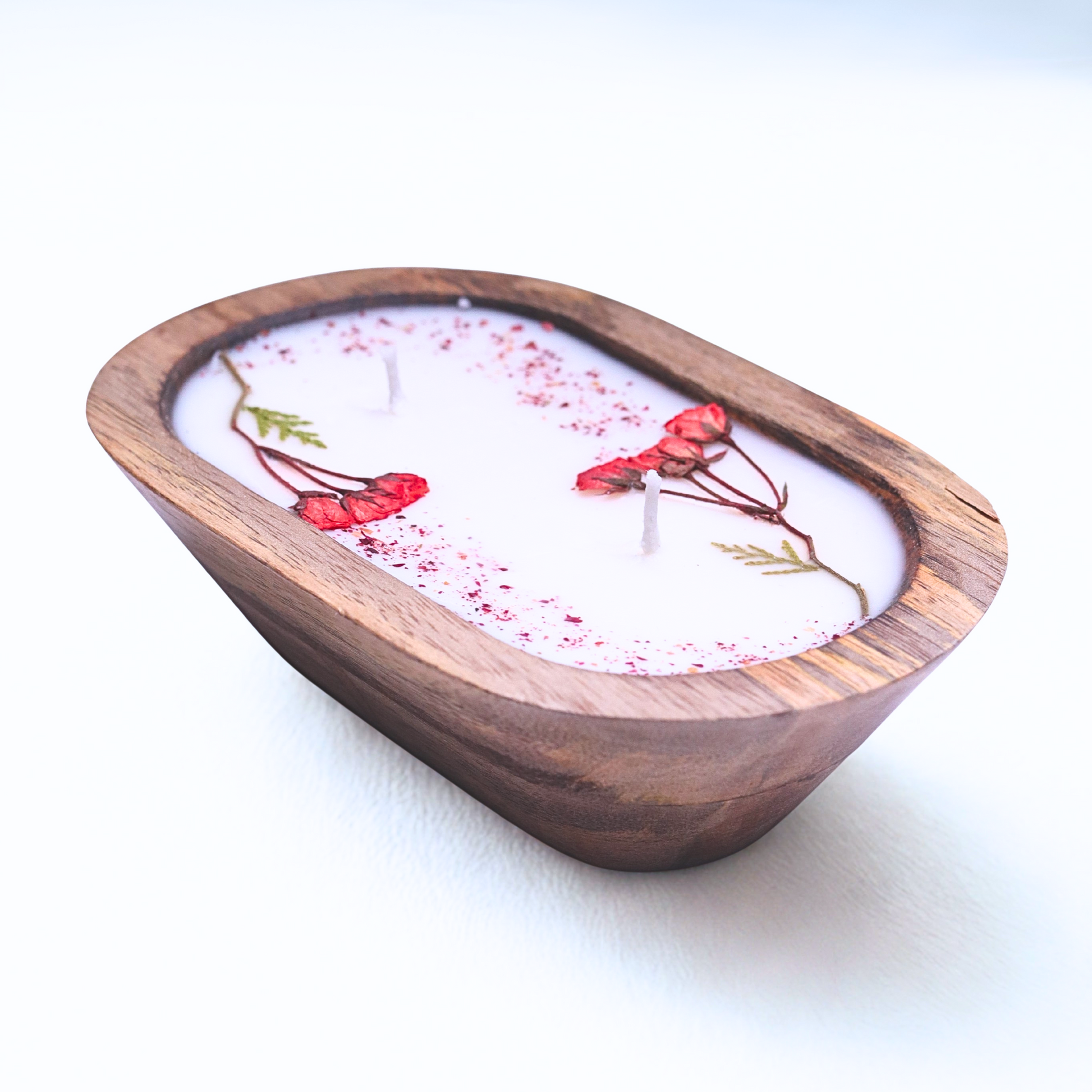 Candle in a wooden holder with floral design on a white background