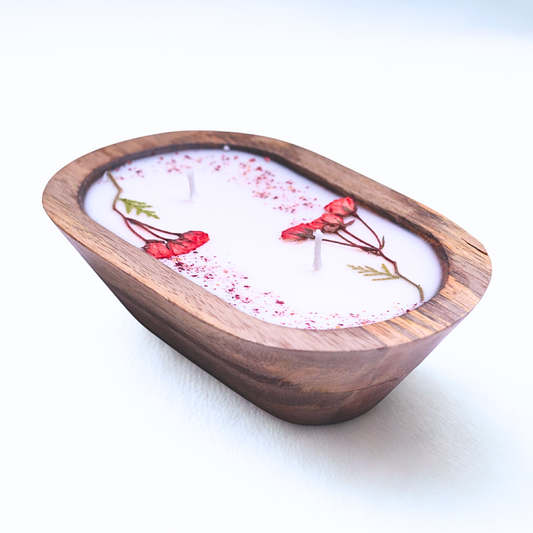 Candle in a wooden holder with floral design on a white background