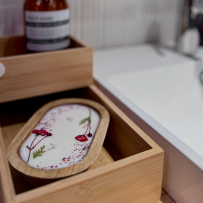 Decorative wooden bowl container with floral design in a wooden box on a kitchen counter.
