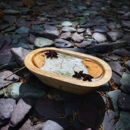 Wooden bowl with a white substance and star anise on a bed of stones