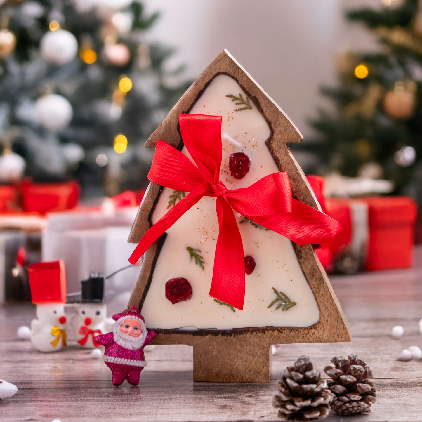 Decorative Christmas tree-shaped gift box with a red ribbon on a festive background.