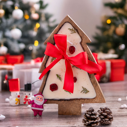 Decorative Christmas tree-shaped gift box with a red ribbon on a festive background.