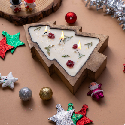 Christmas-themed candle shaped like a tree with decorative ornaments on a brown surface