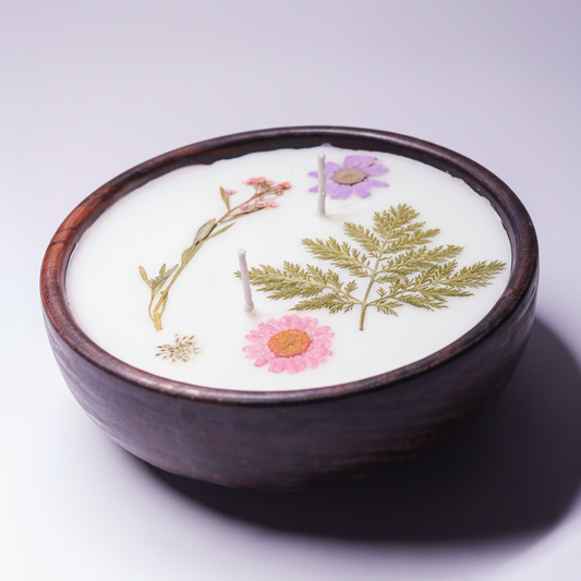 Candle in a wooden holder with floral designs on a white background