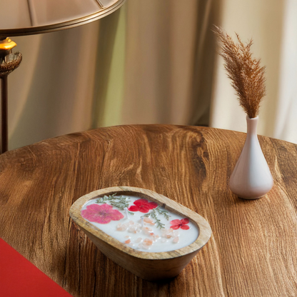 Decorative bowl with floral design on a wooden table next to a lamp and vase.