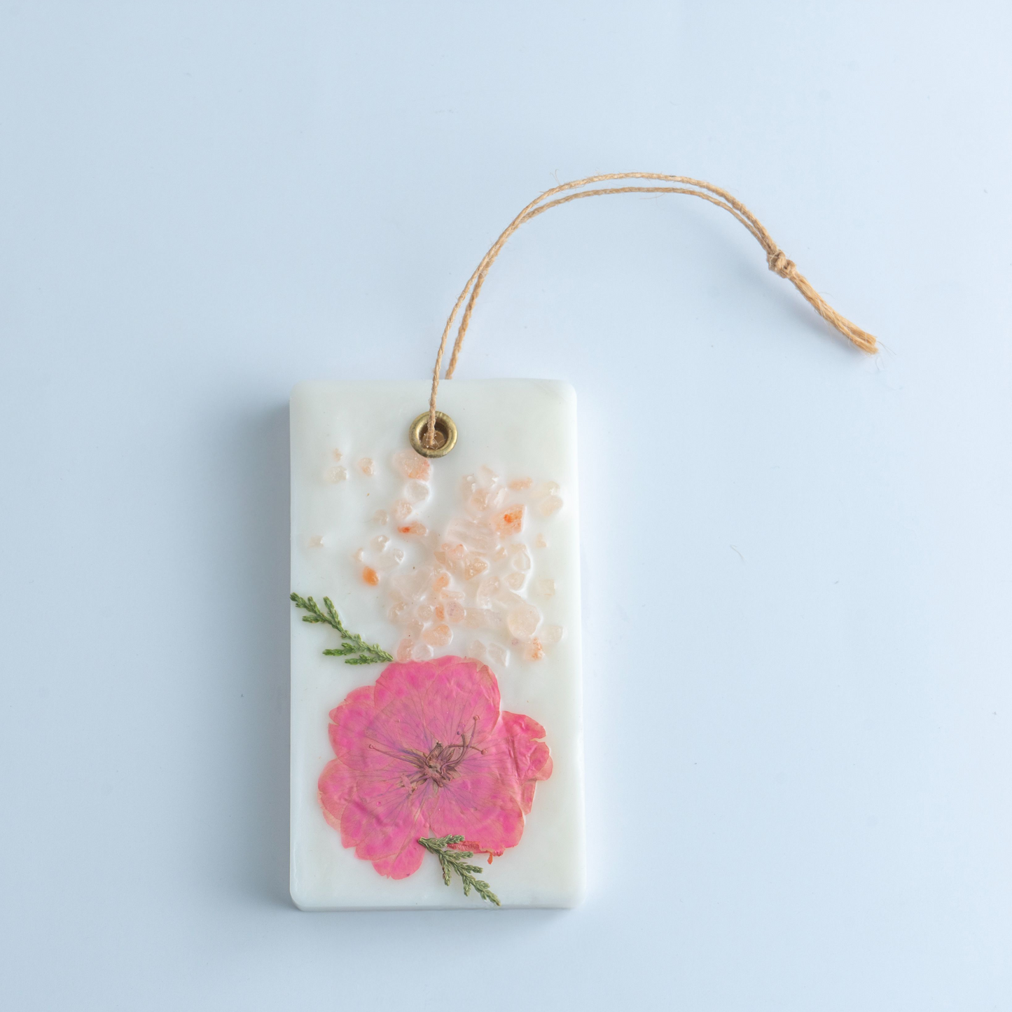 Decorative hanging tag with pink floral design on a light blue background