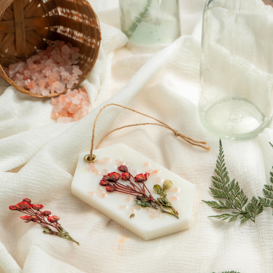 Decorative soap with dried flowers on a white fabric background